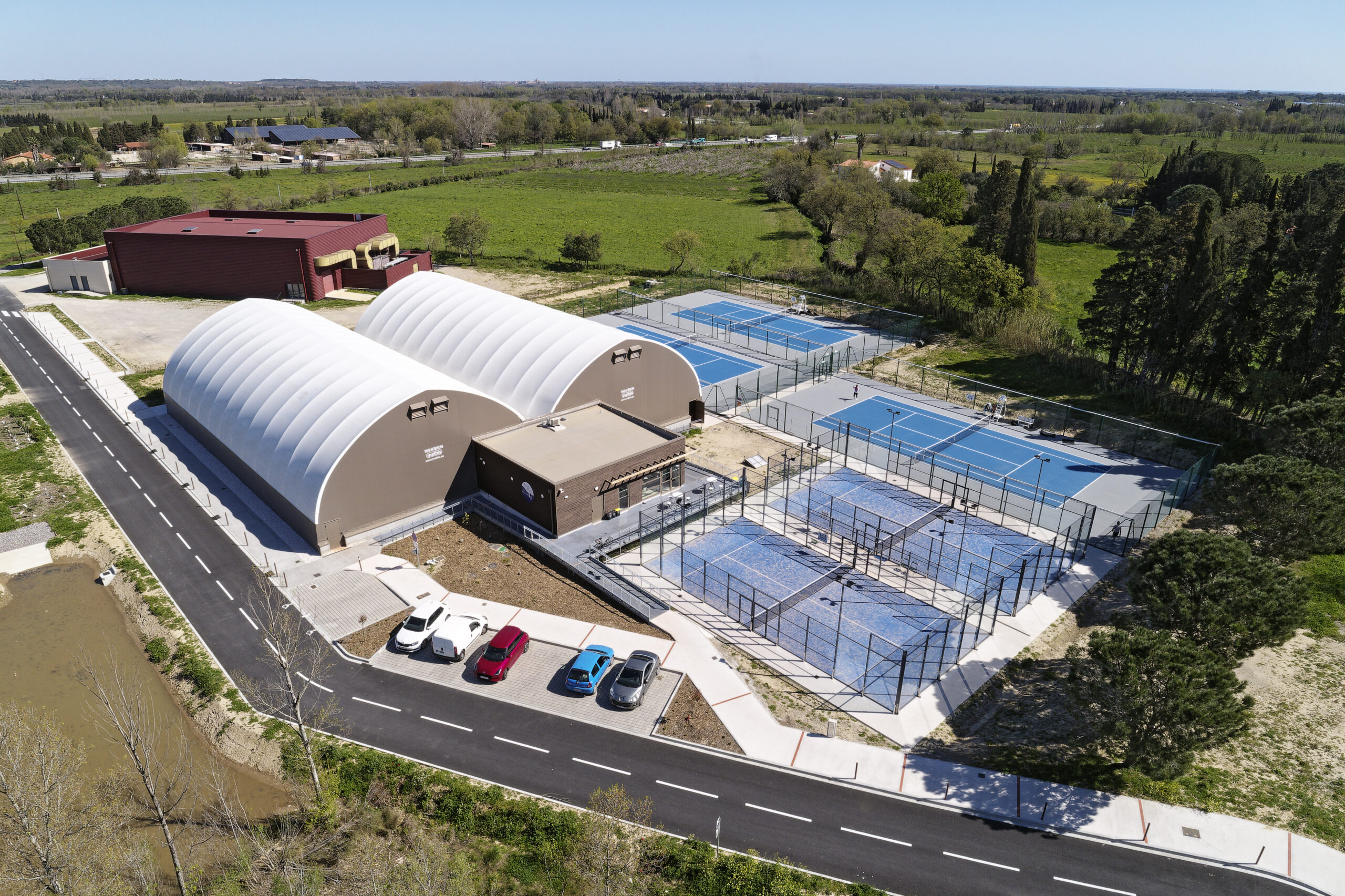 Construction du complexe tennistique de Saint-Genis des Fontaines – halle couverte, terrains extérieurs et padel réalisés par ABC Architecture
